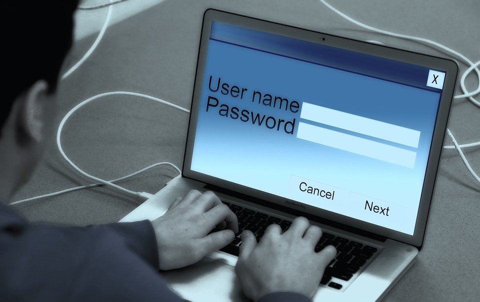 Person typing on a laptop with a login screen showing username and password fields, representing ecommerce account security threats