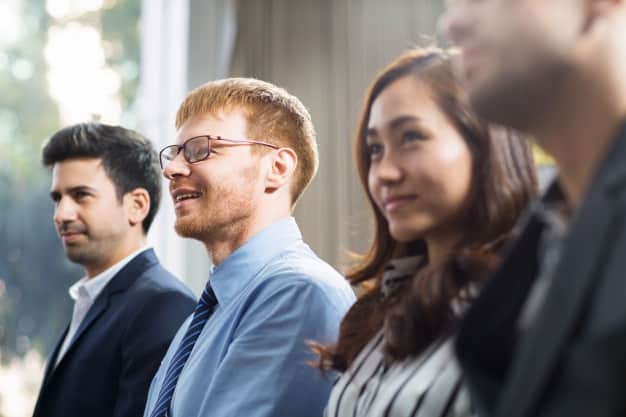Diverse group of professionals smiling and engaged at a business presentation