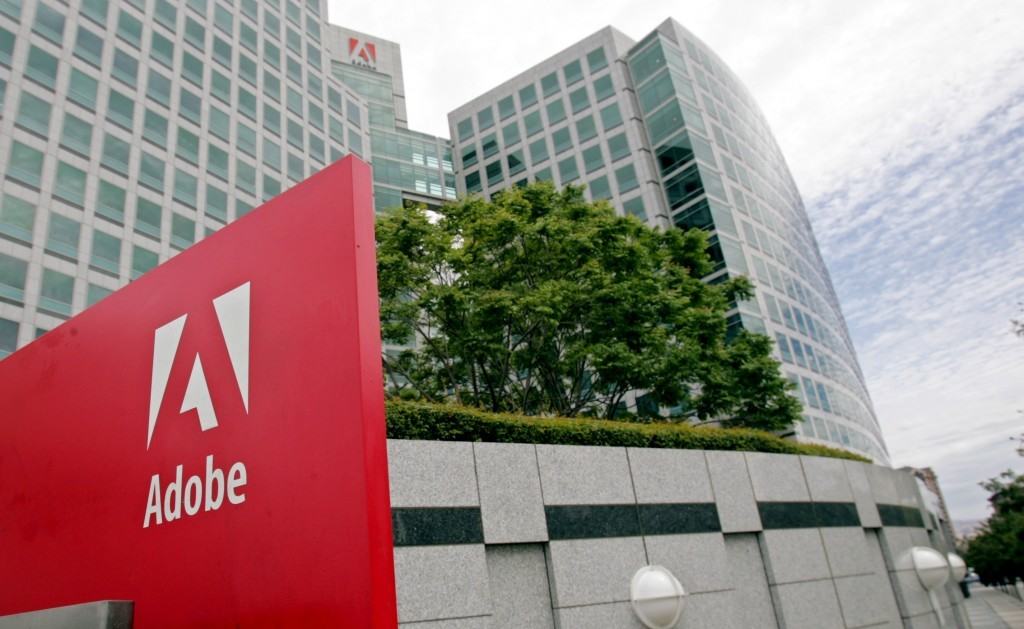 Adobe headquarters building with large red branded sign in the foreground