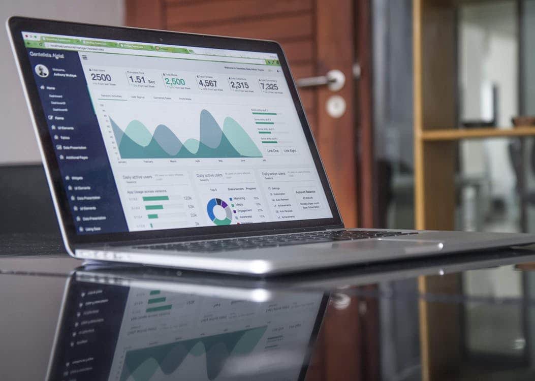 Laptop showing a digital marketing analytics dashboard with traffic graphs and KPI metrics
