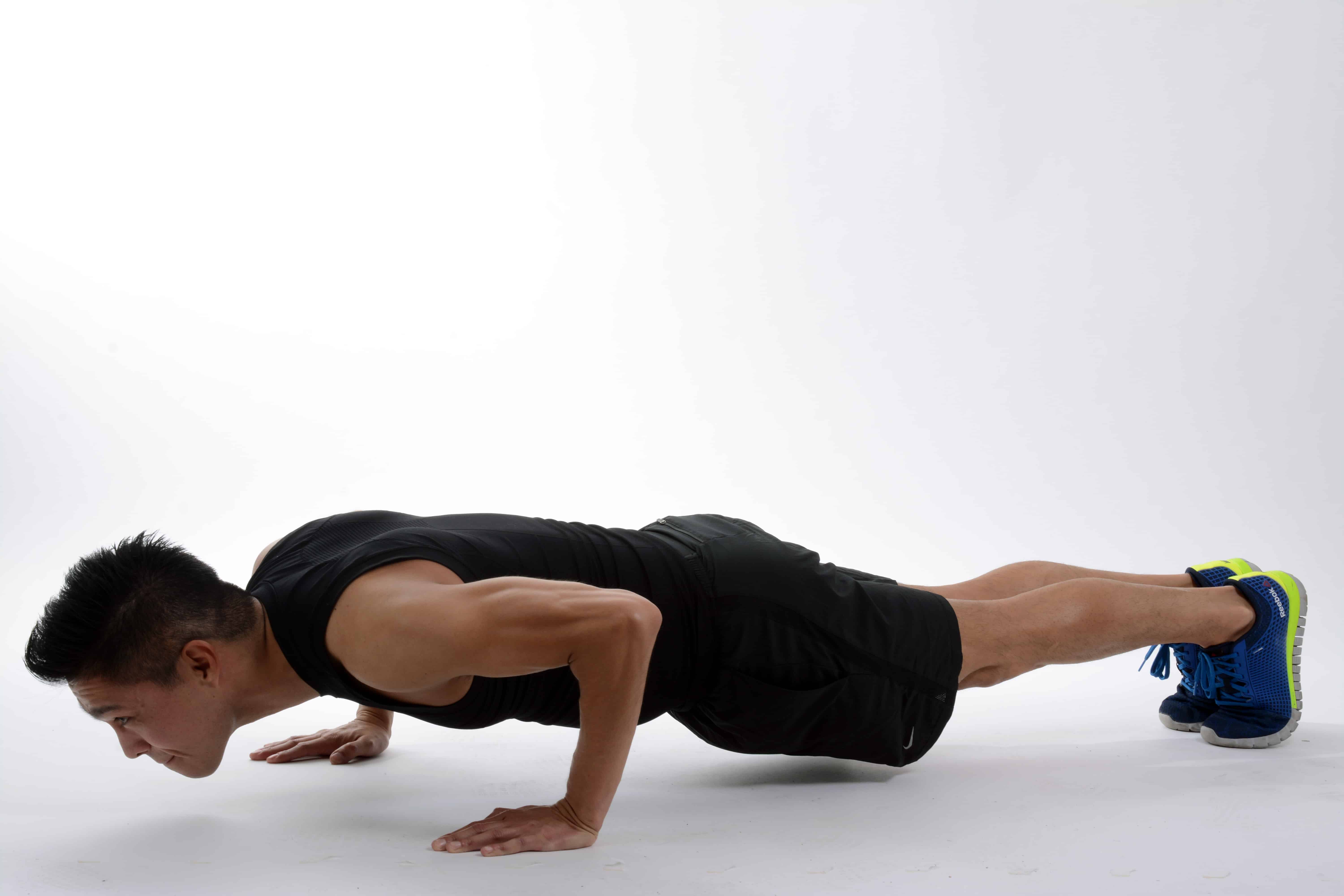 Man doing a push-up on a white background illustrating office exercise tips