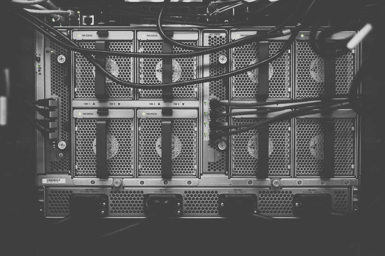 Black and white close-up of rack-mounted data centre servers and cabling, illustrating premium hosting infrastructure